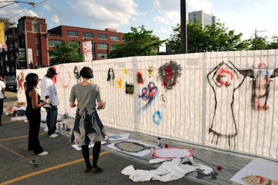 At one of the art-making stations, guests used stencils to create graffiti on a paper wall.