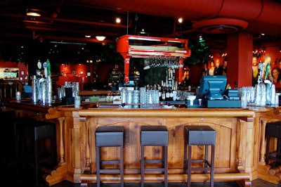 One of the company's signature red pianos is suspended over the main indoor bar.