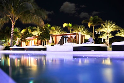 Wooden cabanas and large white beds provide seating around the Blade Pool.