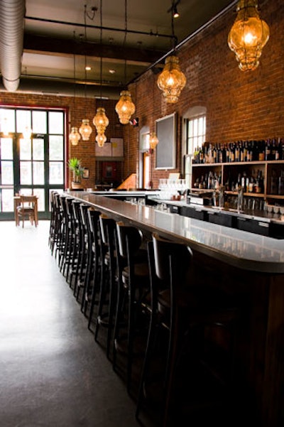 Hand-blown Venetian glass lanterns hang over the white Carrera marble bar.