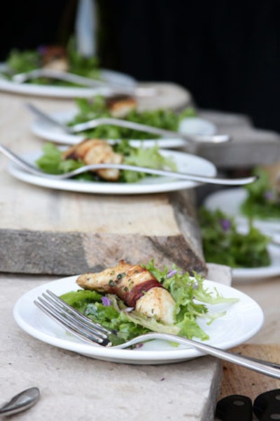Servers handed out small dishes of salad topped with bacon-wrapped whitefish and edible flowers.