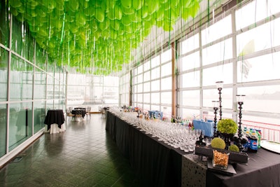Hundreds of green balloons hung overhead in the cocktail area, the attached strings designed to look like blades of grass.