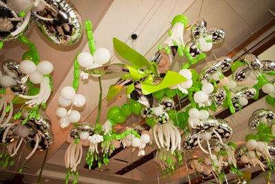 Giant pinwheels and green, white, and silver balloons sculpted into flower-like shapes hung over the gala dinner.