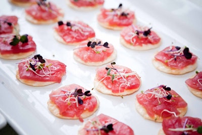 Blowfish served tuna carpaccio with truffle oil and sprouts on rice crisps at one of three food stations.