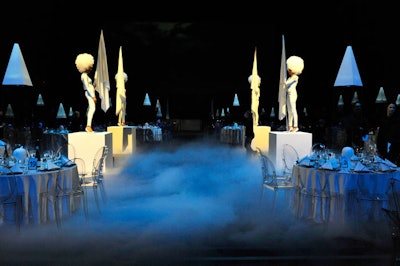 Four models dressed in white body suits and wigs stood guard atop risers on the stage as guests entered the hall for dinner.