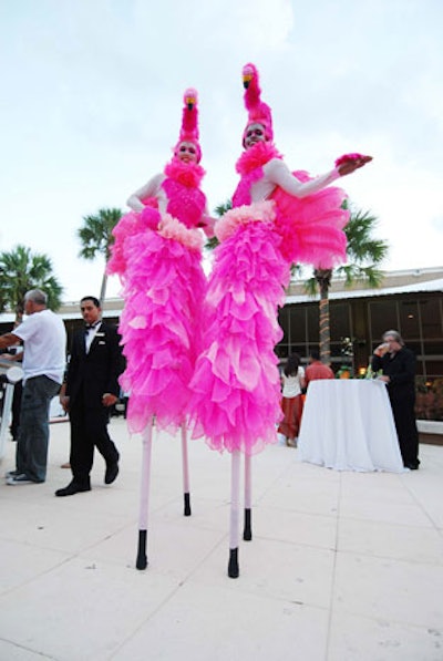 Stilt walkers dressed as flamingos posed for pictures during the cocktail reception.