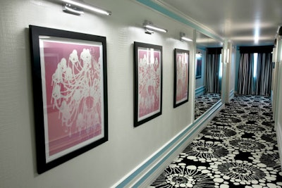 Chandelier images serve as art in hallways, above black and white patterned carpeting.