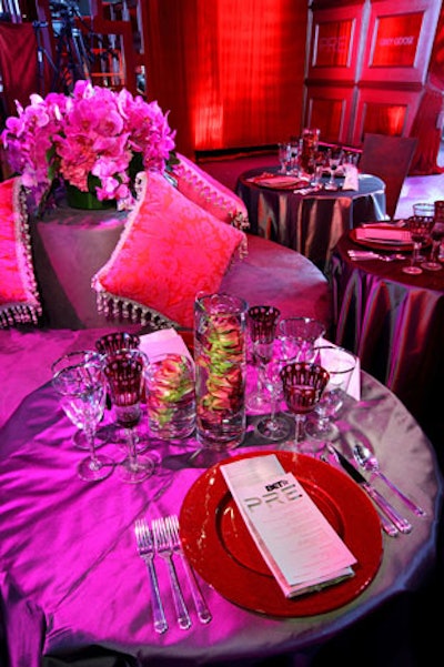 Crimson glass chargers and red-rimmed goblets topped tables.