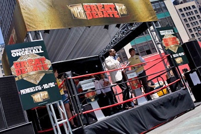 Designed to look like a boxing ring, the publicity stunt's stage also included lecterns for the debate teams and plenty of VH1 promotional signage.