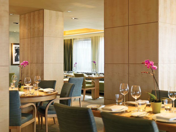 The bright, modern dining room features blond-wood tables and chairs.