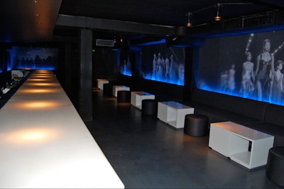 Hologram-like images of runway models cover the club's black walls.