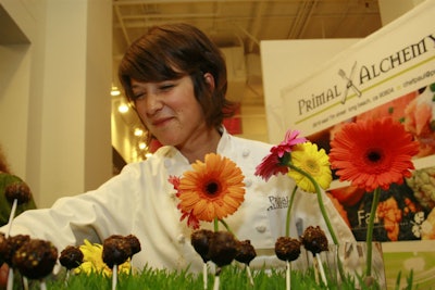 Primal Alchemy offered dark chocolate truffle pop samples artfully displayed on a bed of green grass.