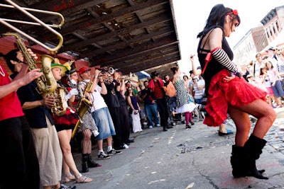 The Hungry March Band, a group of more than 20 musicians, lined up below one of the meatpacking district's many old packing plant awnings during their performance.