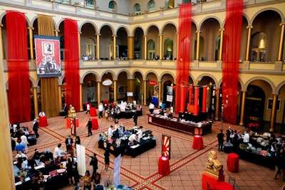 The east wing of the National Building Museum focused on industrial China, with red banners, red tabletops, golden lion statues, and posters referencing Mao-era propaganda.