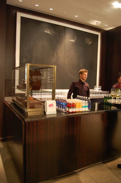 Servers offered wine, beer, and Vitaminwater to guests at a bar in the menswear department.