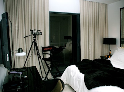 The bungalow's bedroom features a fur blanket, Veuve Clicquot champagne bottles, and a director's chair branded with the show's name.
