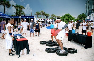 One element of the five-part cocktail-making obstacle course required participants to run through tires with a tray and bucket of sand representing a bucket of ice, the first step in the drink process.