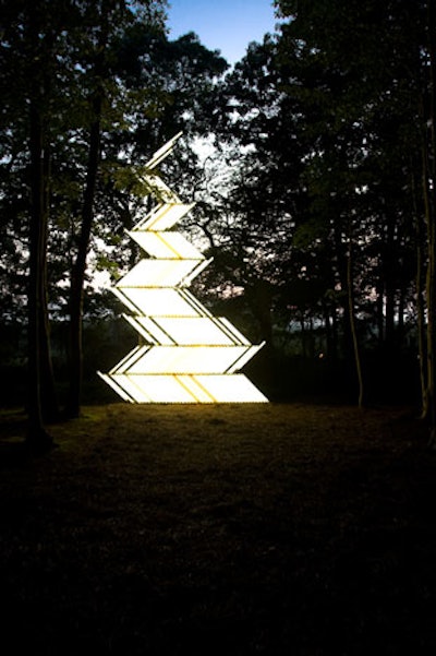 A tower of fluorescent lights stood in the middle of the woods.