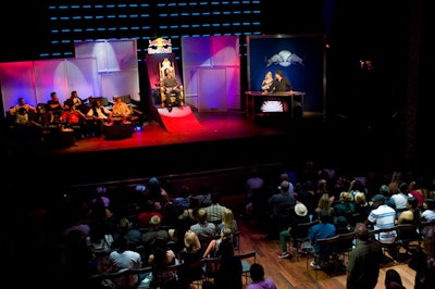 Blue and red lighting washed white panels at Red Bull's event, and Pastrana sat front and center.