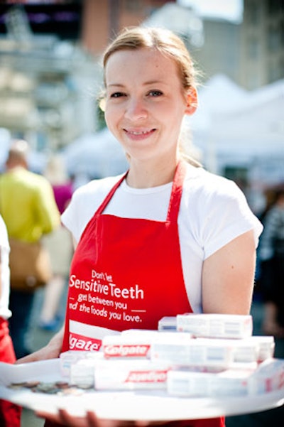 Colgate's red-hued booth included aproned staffers handing out toothpaste samples.