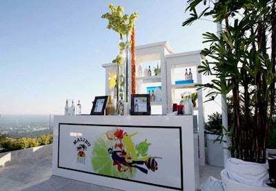 Malibu and Reef Check logos fronted a bar topped with towering greenery at the event celebrating the collaboration between the beverage brand and the nonprofit.