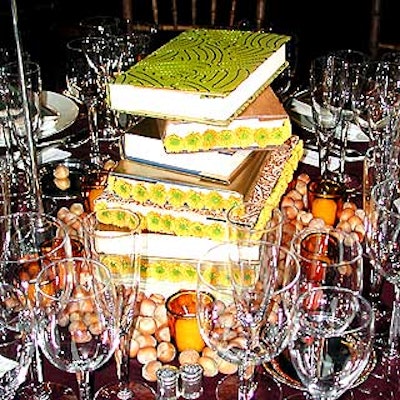 For the New York Public Library's Library Lions benefit, Avi Adler placed stacks of hardcover books covered with custom-made paper covers with decorative stitching and pompom flowers, and scattered hazelnuts and yellow votive candles on the table in lieu of traditional centerpieces.