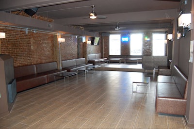 The decor features exposed brick walls and a chocolate and scarlet color scheme.