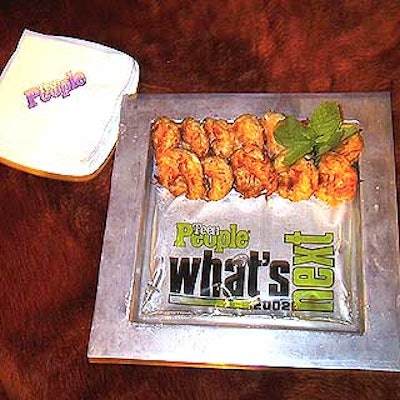 For the after-party in the Grand Ballroom, Tentation served fried coconut shrimp on a silver steel serving plate, made of a similar material to the concert stage, and decorated the plates with branded plastic sacks filled with water.