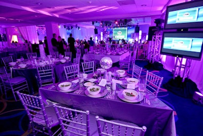 The Extra-Ordinary committee used silver linens, chargers, and chairs along with colorful lighting to decorate the ballroom.