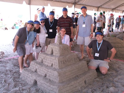 Employees from Teradyne, a company specializing in automatic test equipment, made sandcastles in Gloucester with Fitzy Snowman.