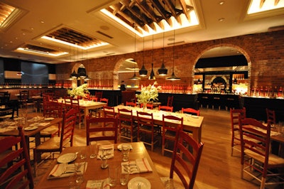 Trattoria Cinque's main dining room is an open 75-seat space with exposed brick, high ceilings, and red accents.