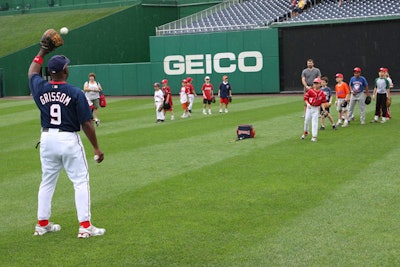 Nationals first base coach Marquis Grissom work with the children on fielding skills.