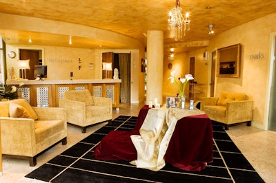 A chandelier crowns the reception area, which is filled with plush seating.