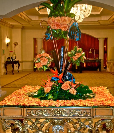 Blooming Design and Events created orange and green centerpieces accented with baseball gloves, mini bats, and balls for the reception area.