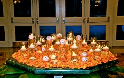 Blooming Design decorated the table at the entrance with orange flower petals and water-filled vases topped with floating candles and baseballs.