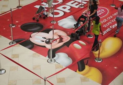 Disney put a large sticker announcing the opening on the floor of the center courtyard and smaller stickers throughout the mall directing shoppers to the store and event.