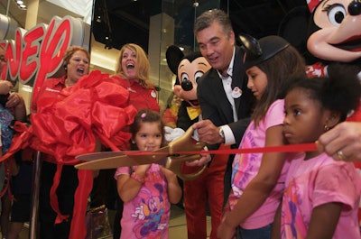 The first three children in line at the store helped Disney store zone director Shawn Powell and Mickey and Minnie conduct the ribbon-cutting ceremony.
