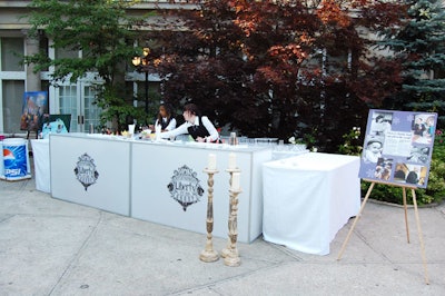 Bartenders at an all-white bar bearing the Liberty Grand logo offered drinks to guests during the cocktail reception.