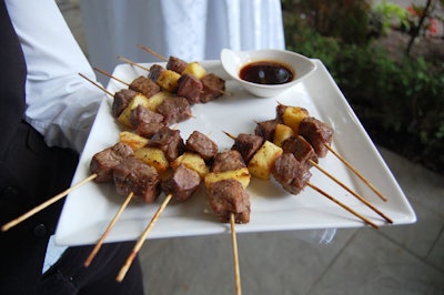 Servers passed beef and pineapple skewers to guests.