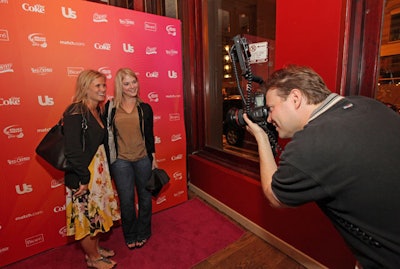 Guests posed for photos in front of a step-and-repeat that called out brands such as Diet Coke and Us Weekly.