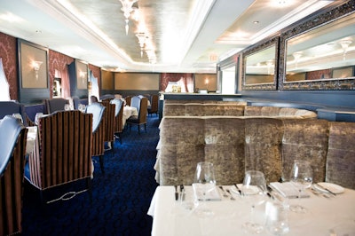 Silver leaf highlights the ceiling in the formal dining room, which has damask-covered walls and is lit with crystal fixtures.