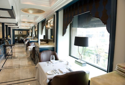 The gallery, a long narrow space with five tables for two, has marble inlaid floors and a wall of blue agate detailing open kitchen.