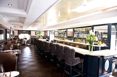 Crocodile-embossed leather walls, mother of pearl details, fabric woven with copper, and a long onyx-topped bar fill the lounge.