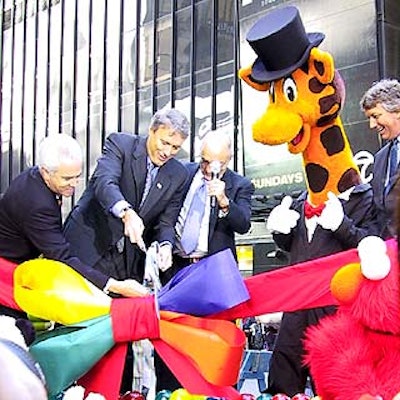 Elliott Wahle, vice president and general manager of Toys 'R' Us Times Square; John Eyler, chairman and CEO of Toys 'R' Us Inc.; Charles Lazarus, founder of Toys 'R' Us Inc; Toys 'R' Us mascot Geoffrey; and Gregory Staley, president of Toys 'R' Us perform the ceremonial ribbon-cutting of the new Toys 'R' Us store in Times Square.