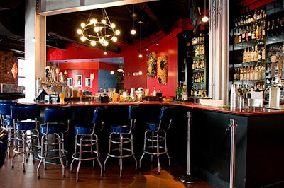 Bright blue patent leather bar stools line the U-shaped quartz bar.