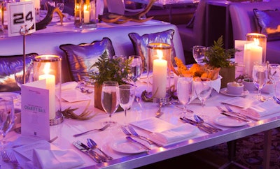 Candles and simple fern centerpieces topped tables in one of three sections in the dining room.