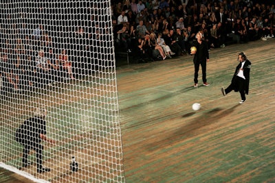 To end his show and entertain the crowd, Y-3 designer Yohji Yamamoto brought French soccer player Zinedine Zidane to join him on the runway. As the two kicked balls at the net, a photographer from the pit volunteered to act as the goalie.