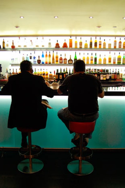 The bar at the front of the restaurant reflects Massimo Vignelli's modern design with simple stools and illuminated surfaces.