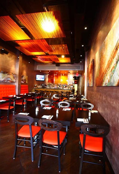 Tre Italian Bistro is decorated with contrasting orange, black, and dark wood furnishings and lighting.