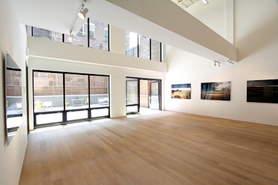 The gallery on the main floor is a 1,500-square-foot space with 22-foot ceilings and glass doors that lead to an enclosed garden.